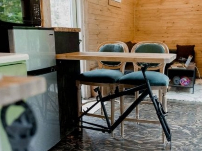 Cabina de contenedores ocultos Riverside - Una original mesa con 2 sillas conforman el comedor.