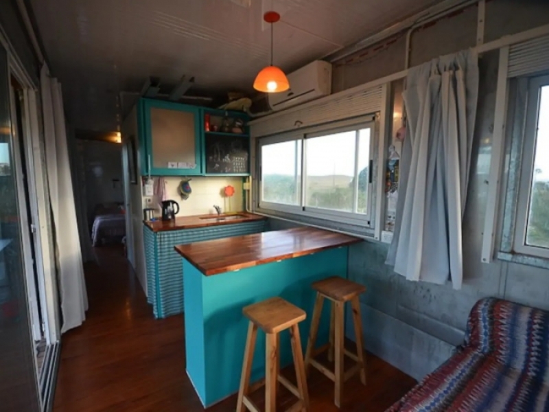 Casa Container de Playa - Combinación de celeste y madera en la cocina con barra.