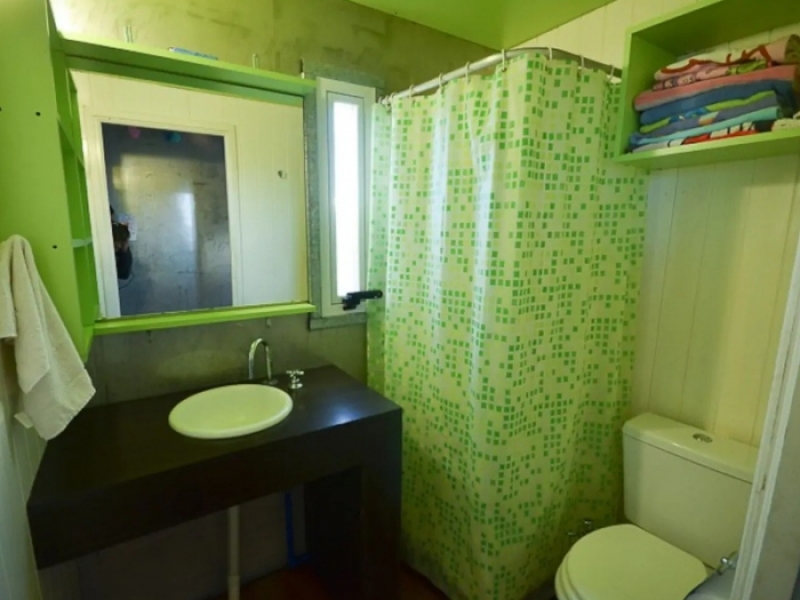 Casa Container de Playa - El baño completo en un delicado verde claro.