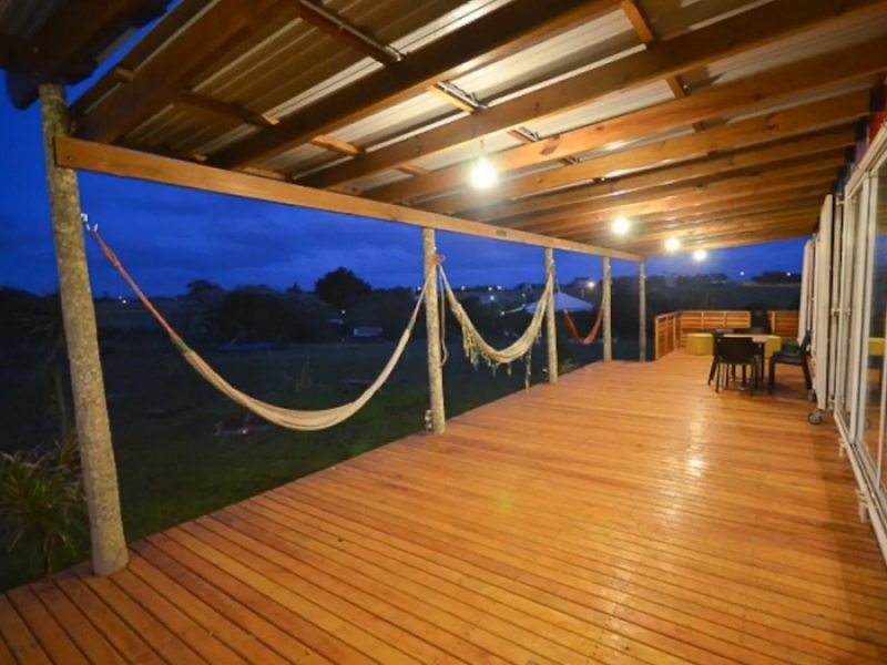 Casa Container de Playa - Amplia terraza de madera cubierta y abierta para disfrutar del paisaje y la tranquilidad.