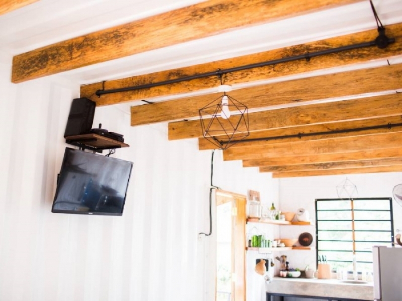 El contenedor Haus - TV en la pared y tirantes de madera en el techo