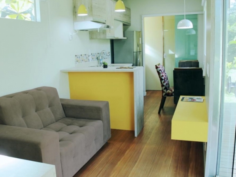 Casa Container Setemares - El marrón de los pisos armoniza con el blanco y amarillo de la decoración.