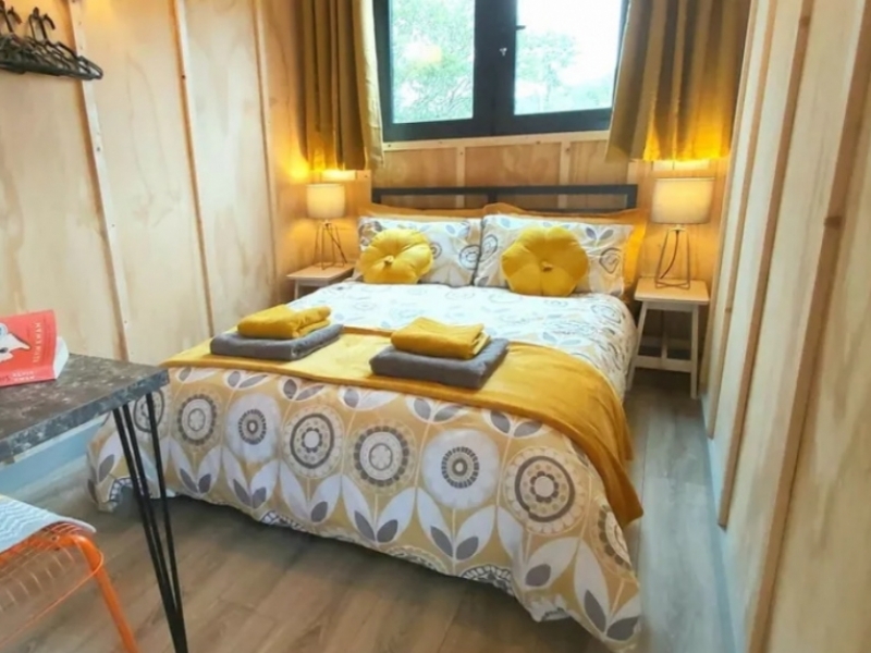 Tiny Container House en el lago costero de Irlanda - Una cama queen con mesas de noche en el dormitorio de exquisito decorado.