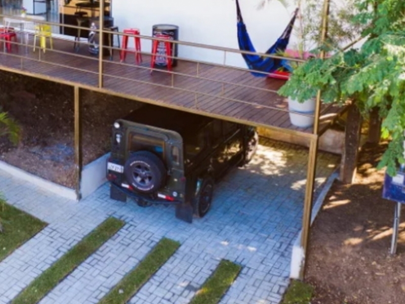 Una casa contenedor debajo de las ramas de los árboles - Brasil - Estacionamiento privado debajo de la casa.
