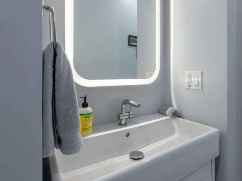 Casa contenedor de 40 pies - EE. UU. - El tocador del baño con espejo y lavabo con mueble.