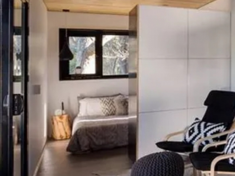 Casa contenedor con estilo por menos de 50.000 - Cama doble y originales mesas de noche en el dormitorio.