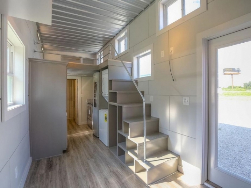 El contenedor de envío vacío Nester Home - EE. UU. - Escalera que lleva al loft con compartimientos y baranda.