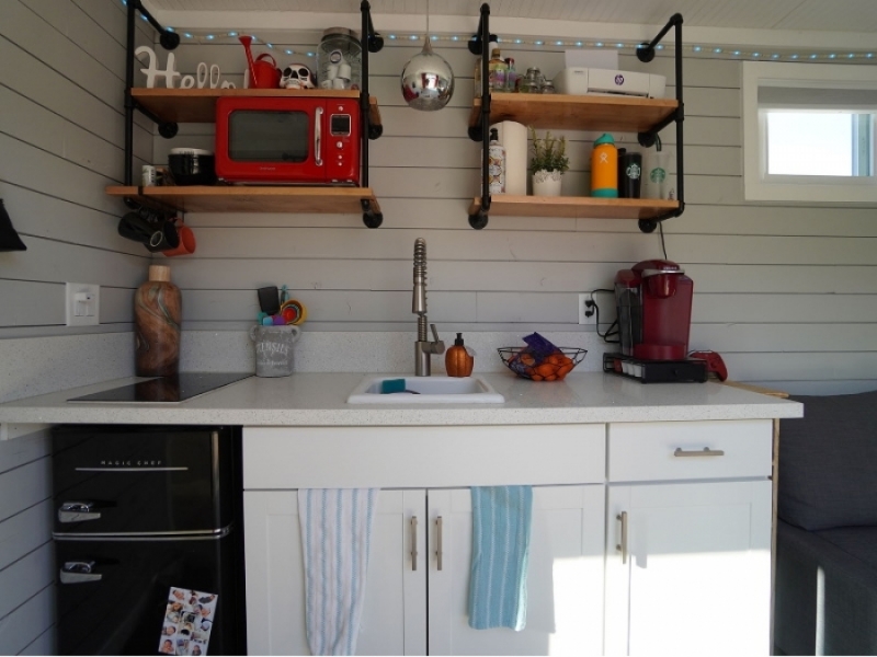 Alt galería de un dormitorio - Originales estantes en madera y caño en la cocina.