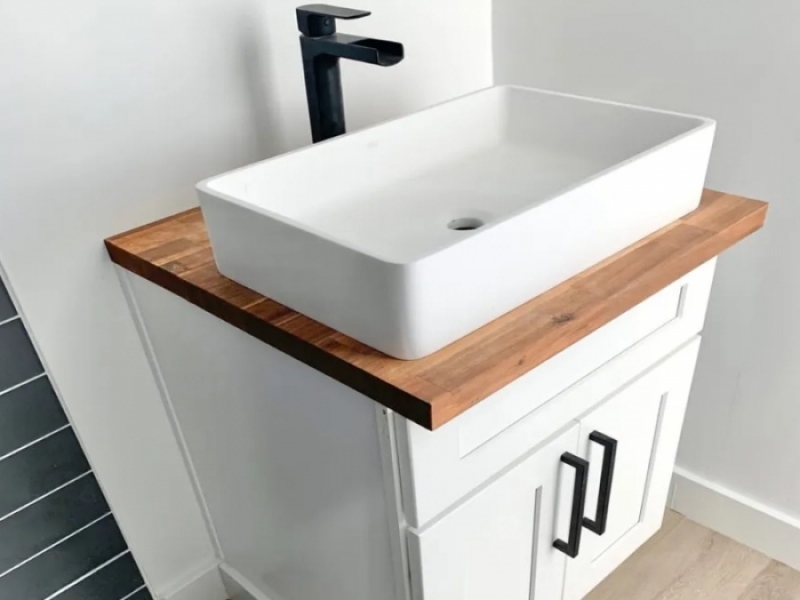 Casa contenedor de granja de $ 70,000 - Lavabo con mueble de madera blanco con detalles en negro.